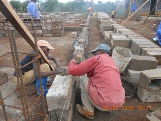Zwischen den Stahlarmierungen für die Betonpfeiler werden die Mauern aus Hohlsteinen hochgezogen